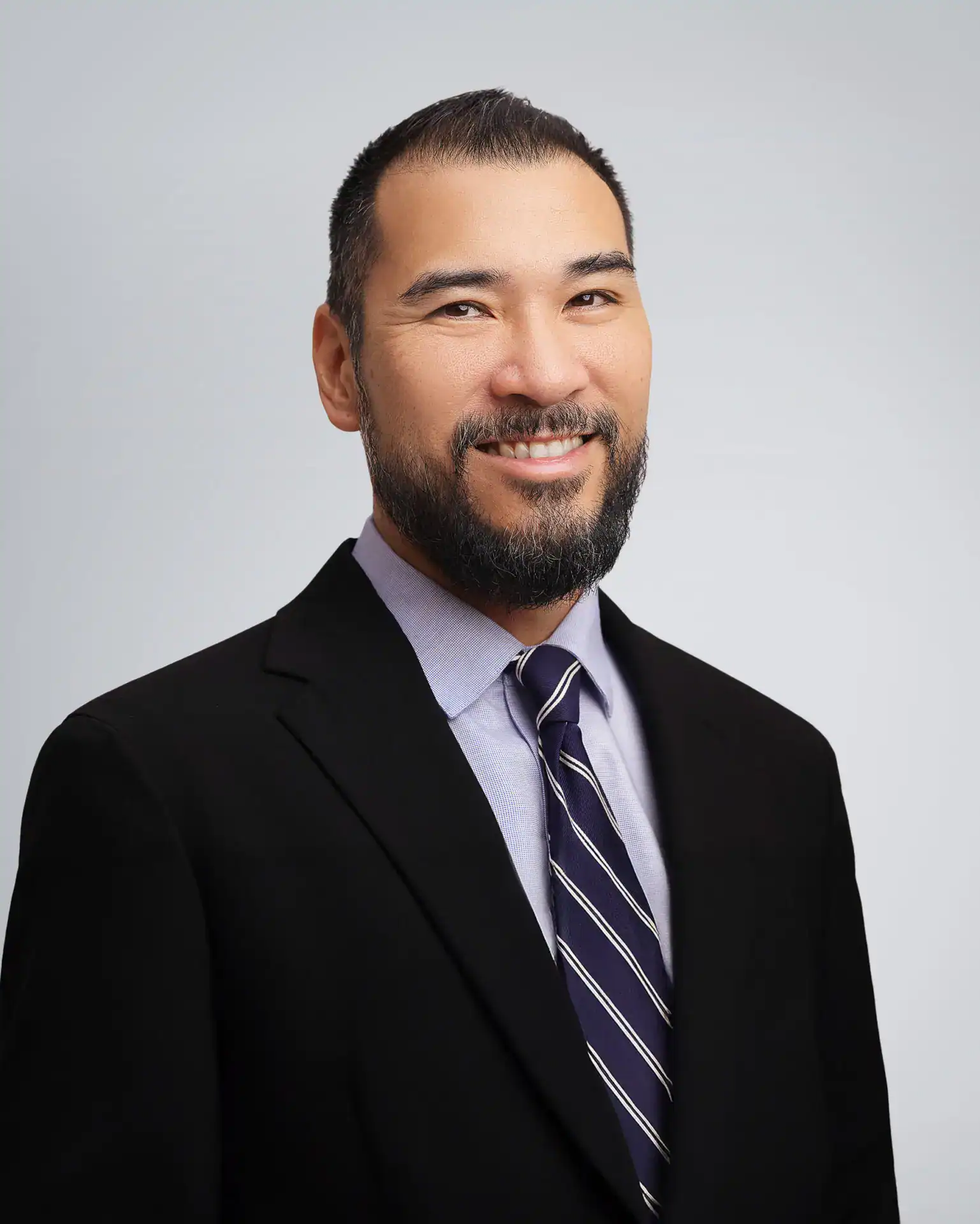 Male attorney in professional attire smiling at the camera.