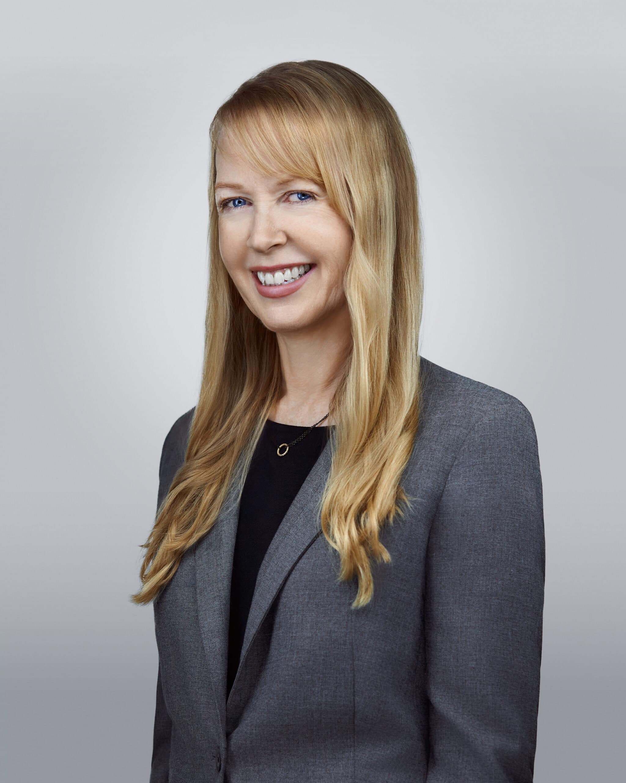 Doll Amir Eley, attorney at law, smiling confidently in a gray blazer.